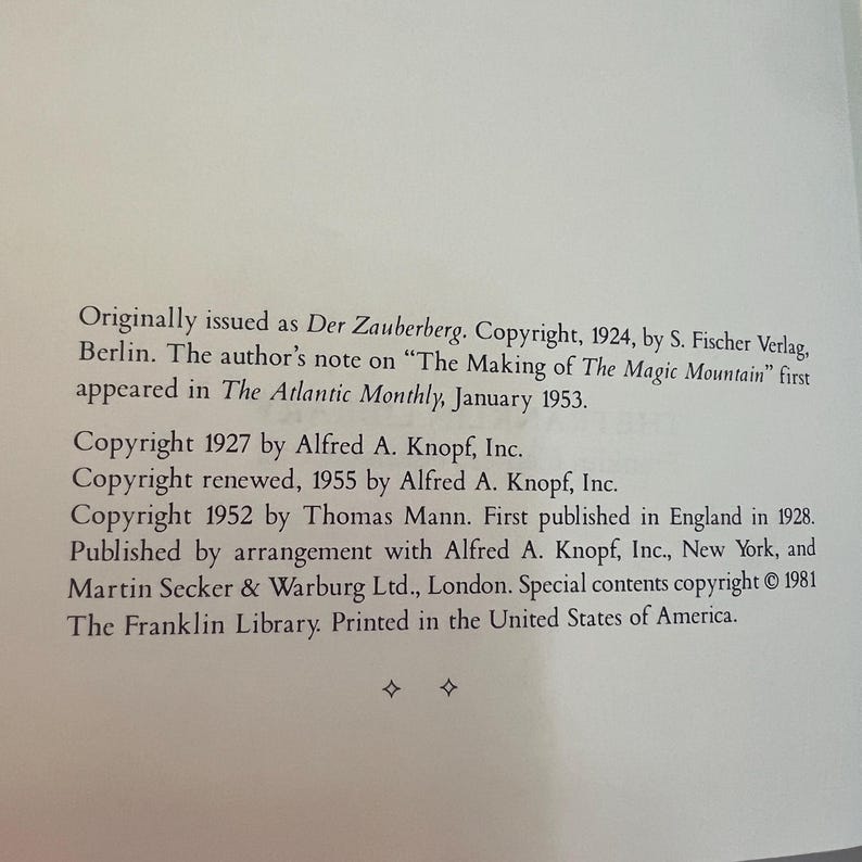 May include: A page from a book with text detailing copyright information. The text includes the original publication details of "Der Zauberberg" and "The Making of The Magic Mountain", along with copyright dates and publisher names.
