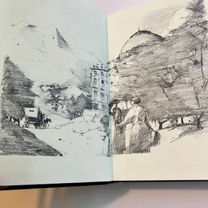 May include: A black and white sketch in a sketchbook depicts a mountain landscape with a building and figures. A horse-drawn carriage is on a road. The sketch style is detailed, with shading used to create depth and texture.