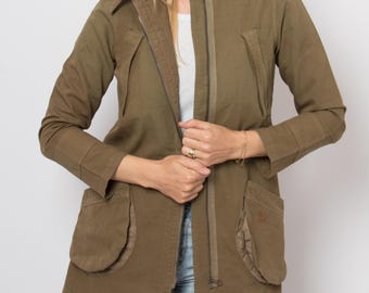 May include: Olive green jacket with a high collar, zip closure, and multiple pockets. The jacket has a tailored fit and is made of a durable fabric. The sleeves have a cuff detail. A stylish outerwear piece.