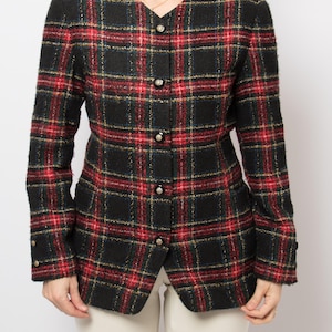 May include: A black, red, and green plaid blazer with a V-neckline and button closure. The blazer has long sleeves and a tailored fit. The plaid pattern is a classic design, suitable for a variety of occasions.