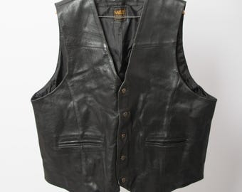 May include: Black leather vest with a classic design. It has a V-neck, button closure, and two front pockets. The vest is hanging on a wooden hanger. The interior lining is black. A classic piece of apparel.
