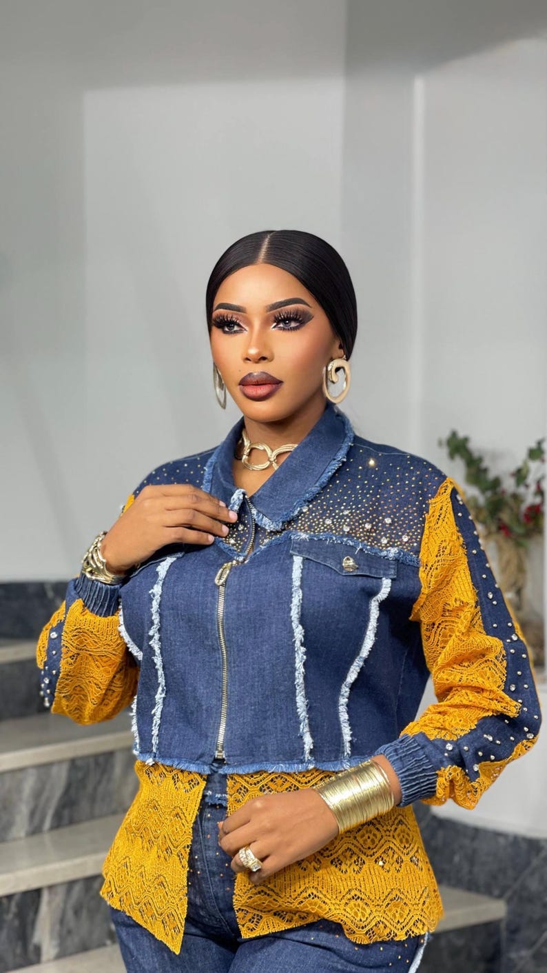 May include: A denim jacket with yellow lace sleeves and accents, embellished with rhinestones. The jacket has a zipper closure and is paired with a matching yellow lace top. Gold jewelry, including a necklace, earrings, and bracelets, completes the look.