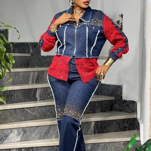 May include: A denim jacket and matching jeans set. The jacket has red sleeves and a red lace panel, with rhinestone embellishments. The jeans are dark wash with white trim and rhinestone accents. The outfit is worn with black sandals.