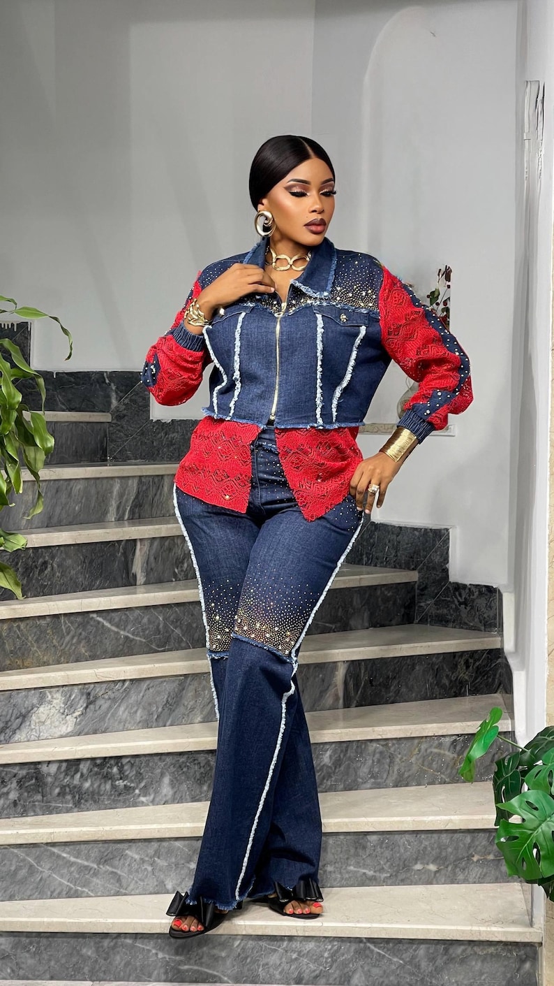 May include: A denim jacket and matching jeans set. The jacket has red sleeves and a red lace panel, with rhinestone embellishments. The jeans are dark wash with white trim and rhinestone accents. The outfit is worn with black sandals.