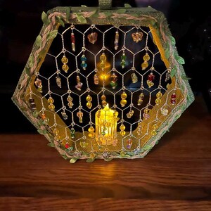 Verzierter Rahmen in Hexagon-Form mit Draht, Perlen und einer Batterieleuchte