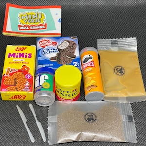 Pode incluir: Uma coleção de alimentos em miniatura, incluindo waffles Eggo Minis, Pringles e um sanduíche de sorvete Good Humor Cookies & Creme. Também inclui um rótulo Mini Verse Real Brands, Cafe Bustelo e pequenas facas de plástico.
