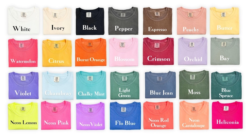 May include: A collection of twenty-eight short-sleeve t-shirts arranged in a grid, each featuring a neck label and a unique color name printed in white text, including White, Ivory, Black, Pepper, Espresso, Peachy, Butter, Watermelon, Citrus, Burnt Orange, Blossom, Crimson, Orchid, Bay, Violet, Chambray, Chalky Mint, Light Green, Blue Jean, Moss, Blue Spruce, Neon Lemon, Neon Pink, Neon Violet, Flo Blue, Neon Red Orange, Neon Cantaloupe, and Heliconia.