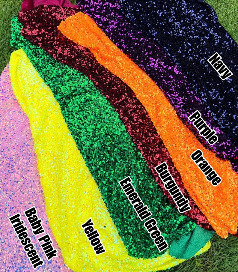 May include: A collection of sequin fabric swatches in various colors, labeled with text: Baby Pink Iridescent, Yellow, Emerald Green, Burgundy, Orange, Purple, and Navy. Each fabric piece is covered in small, reflective, circular sequins.