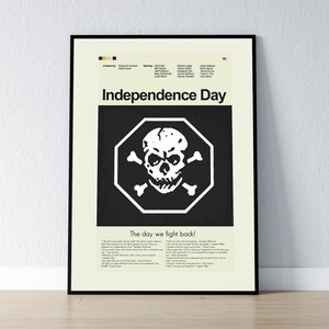 May include: A framed poster for the movie "Independence Day." The poster features a black background with a white skull and crossbones inside a white octagon. The movie title is above the graphic, with the text "The day we fight back!" below.