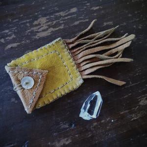 Petite trousse à pharmacie carrée en cuir avec de longues franges, un bouton coquillage et un cristal de quartz