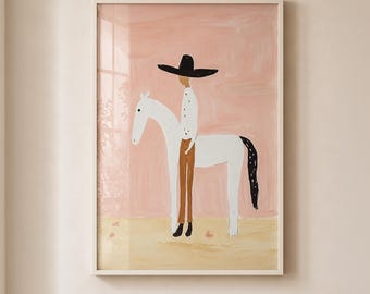 May include: A framed wall art print featuring a stylized illustration of a person wearing a wide-brimmed black hat, a white shirt, and brown pants, standing beside a white horse with a black tail against a solid light pink background.