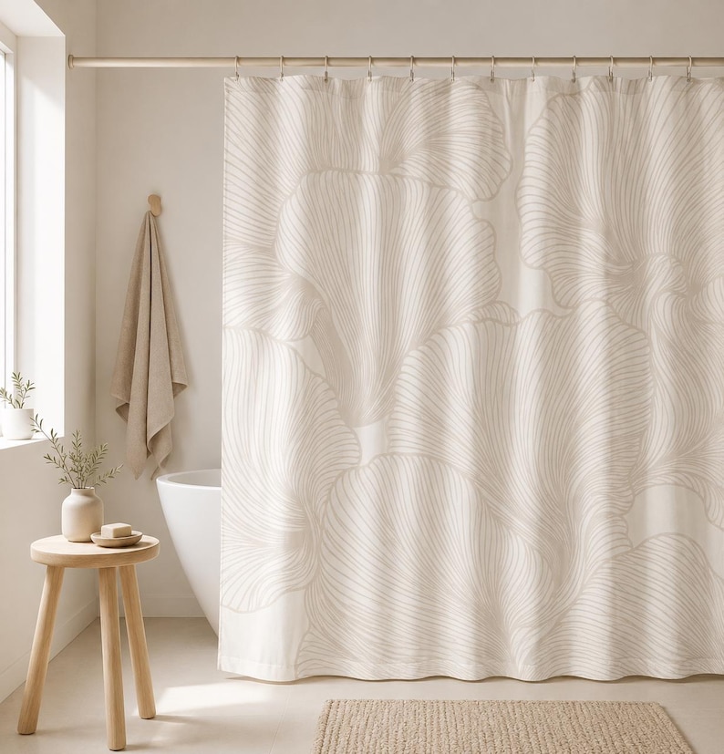May include: A shower curtain featuring a large-scale, repeating pattern of abstract, flowing leaf-like shapes in a soft beige color against a cream-colored background. The design consists of fine, delicate lines that create a sense of movement.