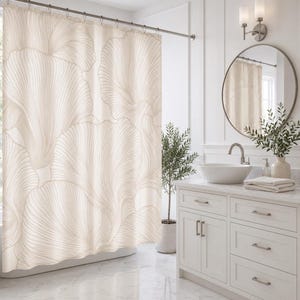 May include: A shower curtain featuring a large-scale, repeating abstract pattern of flowing, fan-shaped lines in shades of cream and beige. The curtain hangs from a metal rod with circular rings, displaying a soft, organic design across the fabric.