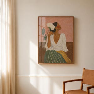 May include: A framed wall art print depicting a person with dark hair wearing a white wrap top and a green and yellow striped skirt. The person holds a large white flower near their head against a pink and brown background with green leaves.