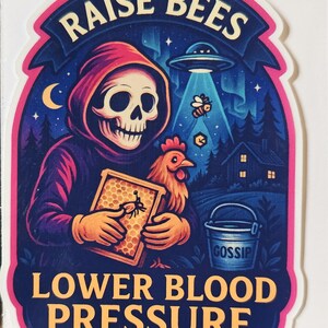 May include: A sticker with a dark blue background and a pink border. It features a skeleton in a red hood holding a honeycomb and a chicken. The text reads "RAISE BEES" and "LOWER BLOOD PRESSURE". A UFO and a bucket labeled "GOSSIP" are also present.