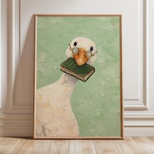 Può includere: Una stampa artistica incorniciata con un'illustrazione stravagante di un'oca bianca con piccoli occhiali rotondi e un libro verde nel becco. Lo sfondo è verde chiaro strutturato e la cornice è marrone chiaro.