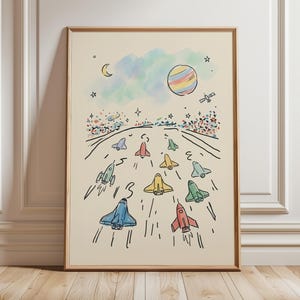 Puede incluir: Una impresión artística enmarcada con una ilustración caprichosa de cohetes coloridos compitiendo en una pista. La obra de arte incluye un planeta arcoíris, una luna creciente, estrellas y un cielo de colores pastel. Los cohetes son de varios colores, incluyendo azul, rojo y amarillo.