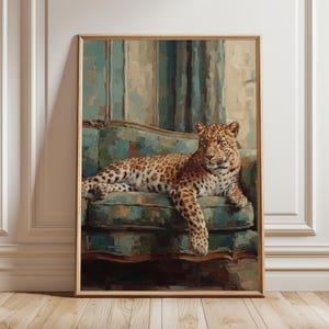 Puede incluir: Una impresión artística enmarcada que presenta una pintura al óleo de un leopardo con manchas doradas y negras descansando sobre un sofá con estampado azul y verde azulado. El leopardo está en el centro, mirando a la derecha, con una pata colgando.