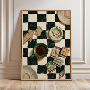 Könnte beinhalten: Gerahmter Kunstdruck mit einem Stillleben aus einer grünen Kaffeetasse, einem Aschenbecher mit Zigaretten, Zuckerpäckchen, Streichholzschachteln und einem Löffel auf einer schwarz-weiß karierten Oberfläche. Die Streichholzschachteln haben Illustrationen.