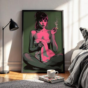 Puede incluir: Una impresión artística enmarcada que presenta una figura sentada con tonos de piel rosados y cabello oscuro, sosteniendo un cigarrillo encendido. La figura está sobre un fondo verde. Una lámpara de pie negra y una cama con ropa de cama gris están en el fondo.