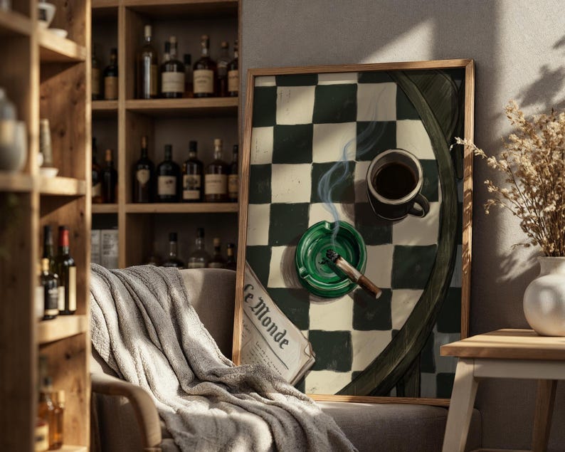 May include: A framed artwork featuring a green and white checkered pattern, a cup of coffee, a lit cigarette in a green ashtray, and a newspaper. The artwork is displayed in a room with a wooden shelf filled with bottles.