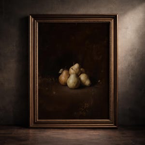 May include: A framed oil painting depicting a cluster of five pears in muted yellow and green tones. The artwork is set against a dark, shadowy background and is enclosed in a decorative, metallic bronze-coloured frame with intricate detailing.