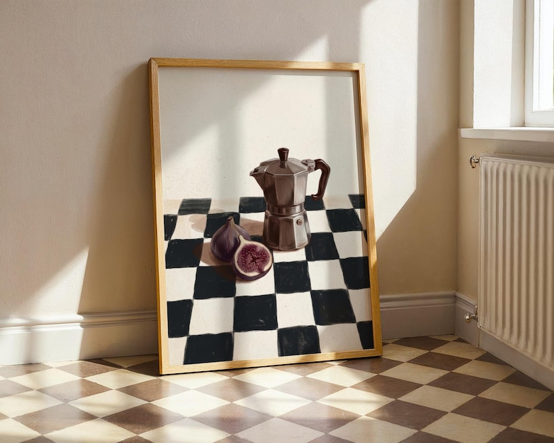 May include: A framed still life painting featuring a brown stovetop espresso maker, two figs, and a checkered black and white pattern. The figs are purple with a red interior. The frame is a light brown color.