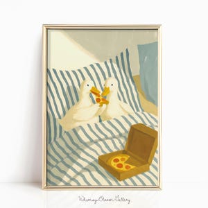 Può includere: Una stampa artistica incorniciata con due anatre bianche che condividono una pizza a letto. Le anatre sono sotto una coperta a righe blu e bianche, con una scatola di pizza nelle vicinanze. L'opera d'arte ha uno stile illustrativo stravagante.