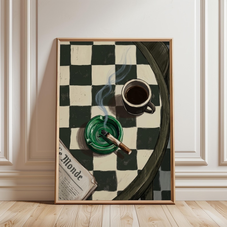 May include: A framed print featuring a still life with a green ashtray holding a lit cigarette, a black coffee mug, and a newspaper with the text "Le Monde". The background is a black and white checkered pattern.