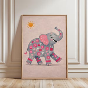 May include: A framed print of a smiling grey elephant with pink ears and accents. The elephant is decorated with pink and red geometric shapes. A yellow sun is in the upper left corner, set against a pink background.