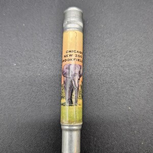 May include: A silver pencil with a yellow and orange label that says "Chicago New Zoo Brookfield" and features an illustration of an elephant.
