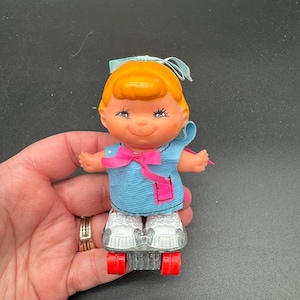 1970s Wind-Up Roller Skating Doll – Kitsch Baby Girl with Blue Dress & Red Wheels – Vintage Toy Made in Hong Kong