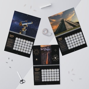 Puede incluir: Tres calendarios negros con espiral y diseños mensuales. El calendario de enero presenta un telescopio contra un cielo estrellado. El calendario de marzo muestra una pirámide al atardecer. El calendario de febrero muestra un paisaje con un sol y estrellas.