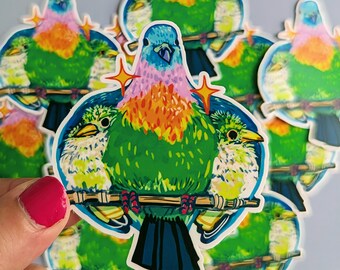 May include: A collection of colorful bird stickers. Each sticker features a vibrant bird design with green, blue, orange, and pink hues. The birds are perched on a branch, surrounded by a blue circle and starburst accents. The stickers are held by a hand with a pink nail polish.