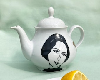 Antique teapot printed with illustrations of a woman's portrait and lemons in black and gold