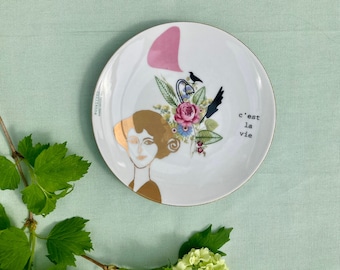 Antique plate printed with a 'Belle Dame' in gold, flowers and the words 'C'est la vie'