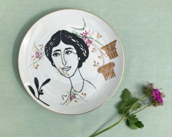 Antiek bordje met pastelkleurige bloemen, kleurrijke met illustraties van vogels en een raam. Bedrukking in goud en zwart.