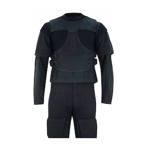Puede incluir: Un chaleco táctico negro con una camisa negra y pantalones negros. El chaleco tiene un panel de pecho con correas y hebillas.
