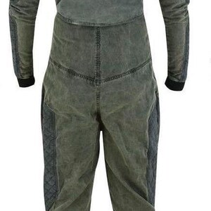 Puede incluir: Un mono de color verde oscuro de manga larga con cuello alto y cierre de cremallera. El mono tiene un aspecto desgastado y presenta dos bolsillos grandes en las piernas.