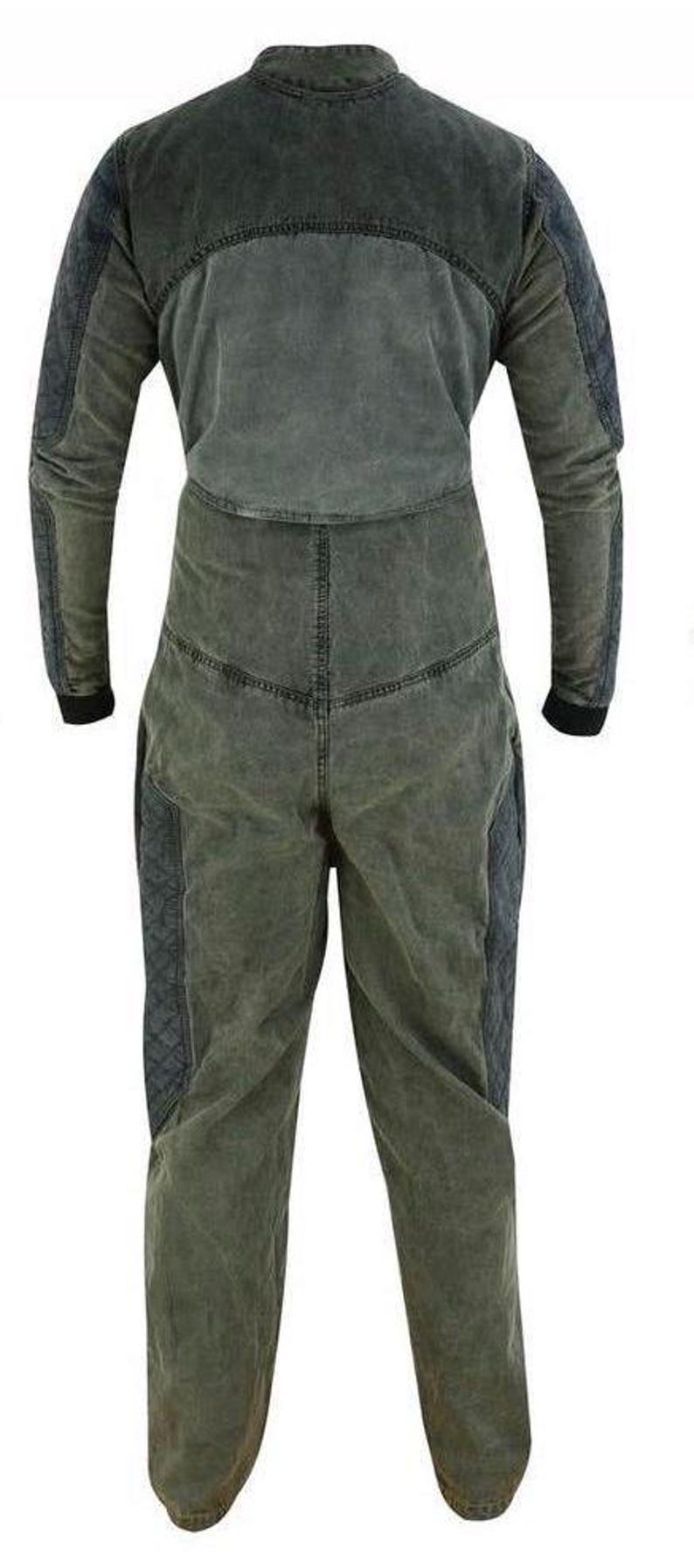 Puede incluir: Un mono de color verde oscuro de manga larga con cuello alto y cierre de cremallera. El mono tiene un aspecto desgastado y presenta dos bolsillos grandes en las piernas.