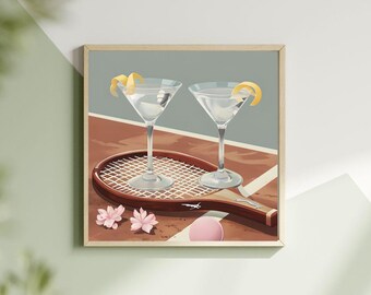 May include: Two martini glasses with lemon twists on a tennis racket on a clay court. The glasses are filled with a clear liquid and there are two pink flowers and a pink tennis ball on the court.