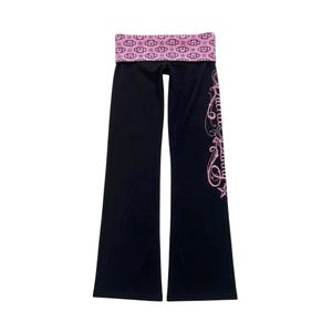 May include: Black yoga pants with a wide pink waistband featuring a pattern of clouds and stars. The pants have a flared leg and a pink cursive design down the side. The pants are made of a soft, stretchy material.