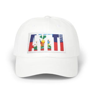 May include: White baseball cap featuring a rectangular patch with the word "HAITI" in a colorful design. The design incorporates the colors of the Haitian flag: red, blue, and yellow. The cap has a curved brim and a classic six-panel construction.