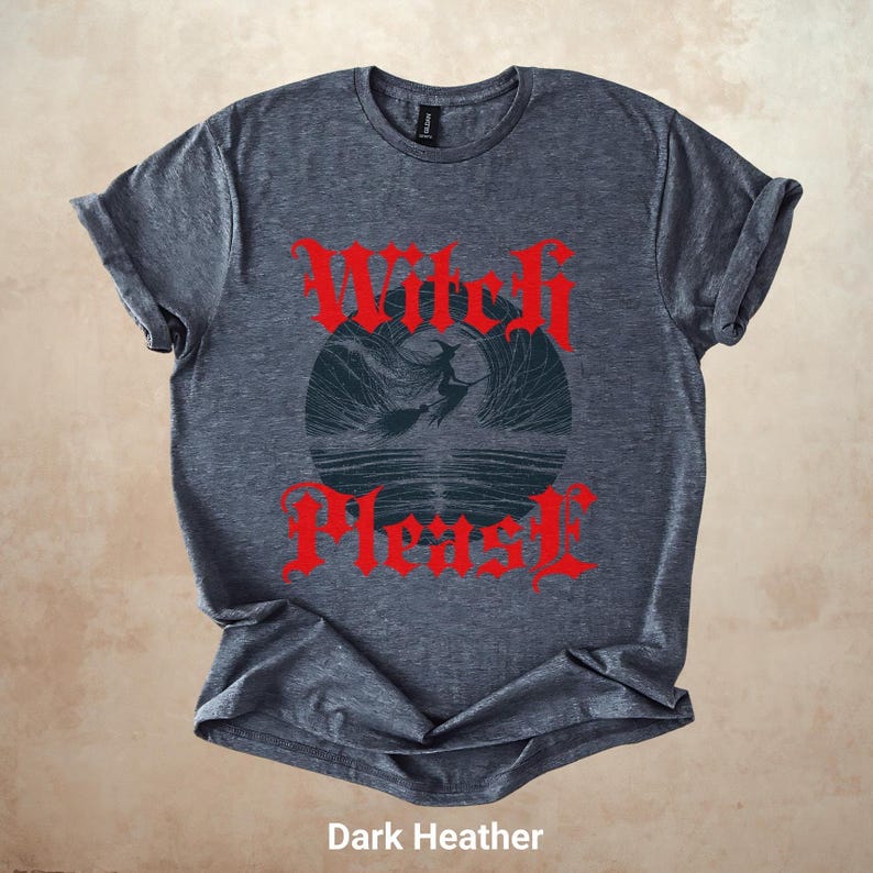 May include: Dark heather gray t-shirt with the text "Witch Please" in red gothic lettering. The shirt features a circular graphic of a witch flying over water. The shirt is made of a soft material.