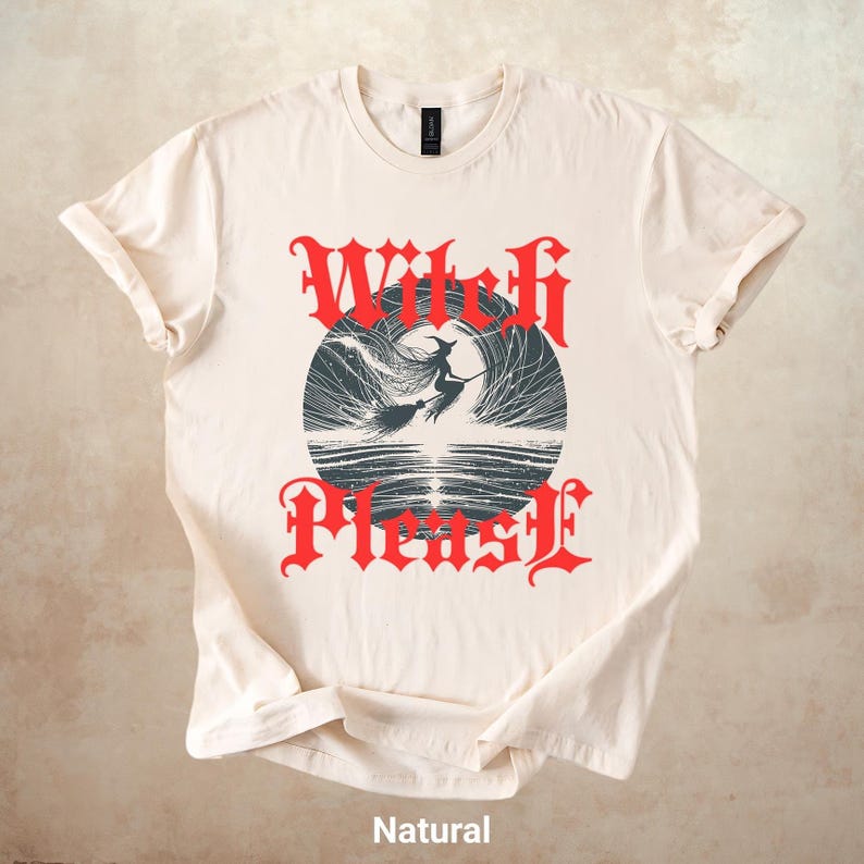 May include: A natural-colored t-shirt featuring a graphic design with the words "Witch Please" in red gothic lettering. The design includes a witch on a broomstick flying in front of a dark circle. The word "Natural" is printed at the bottom.
