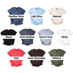 May include: A collection of t-shirts in various colors, including heather navy, light blue, natural, black, dark heather, sports grey, white, red, dark chocolate, and military green. Each shirt is displayed folded with the color name below.