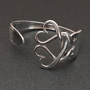 May include: Silver bracelet with a heart design made from a recycled spoon.