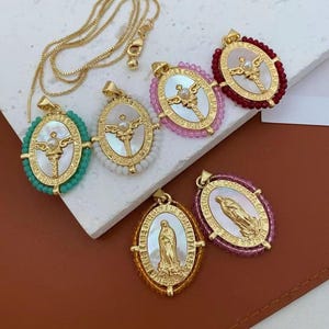 May include: Gold-toned necklaces with oval pendants. The pendants feature religious imagery, including crosses and a depiction of the Virgin Mary, set against a mother-of-pearl background. The pendants are surrounded by colorful beads.