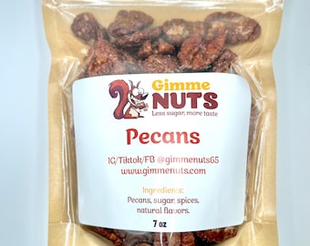 Könnte beinhalten: Ein transparenter Beutel mit kandierten Pekannüssen. Das weiße Etikett trägt die Aufschrift "Gimme Nuts" und "Pecans". Es listet auch die Zutaten und das Gewicht von 7 oz auf.