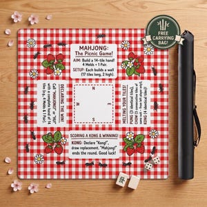 May include: A square Mahjong game mat with a red and white checkered pattern, featuring strawberry and daisy illustrations, black ants, and instructional text. Includes a black carrying case and two white tiles with black characters.